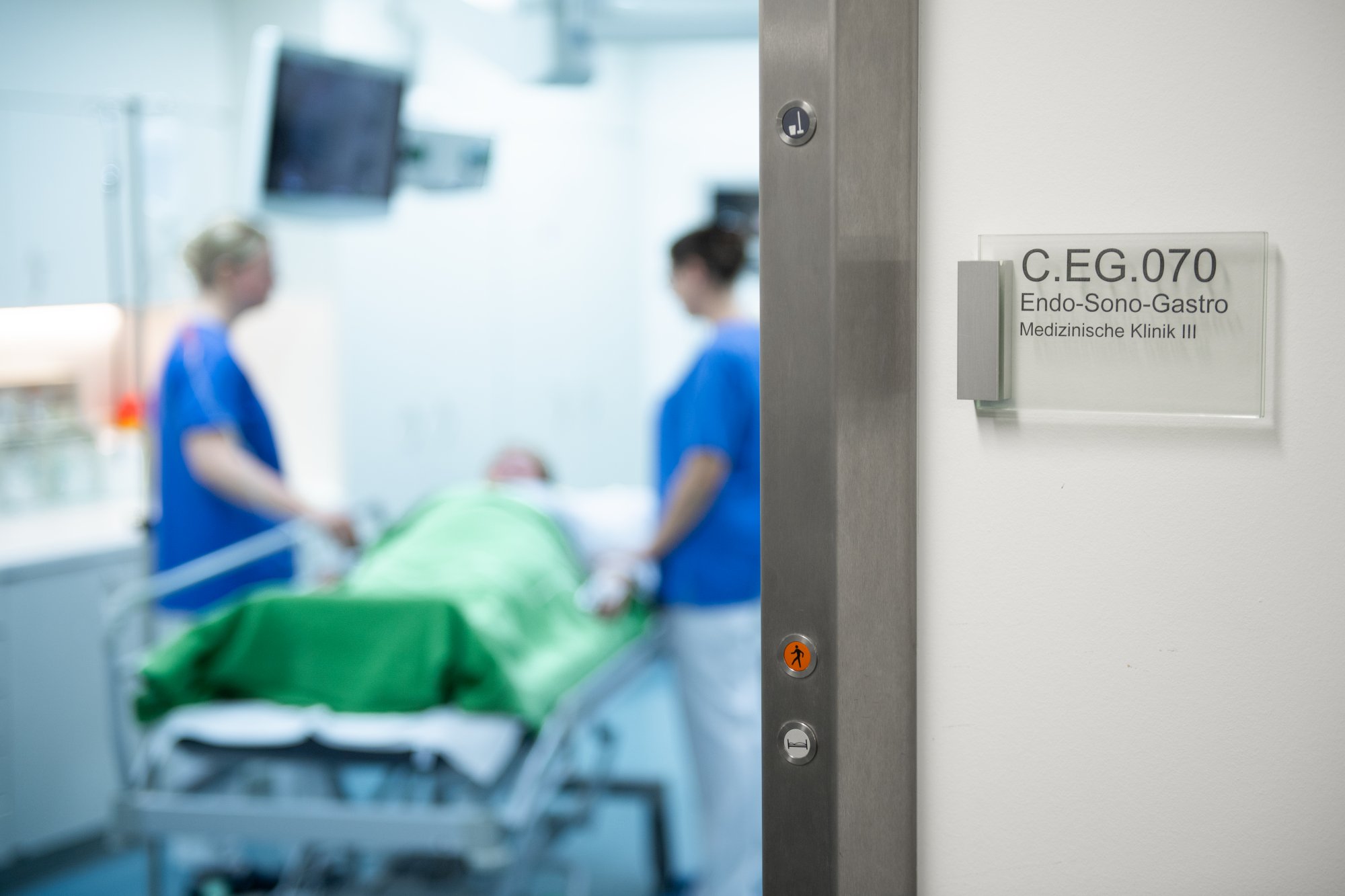 Türschild mit der Raumnummer und dem Text Endo-Sono-Gastro und Blick in das Behandlungszimmer